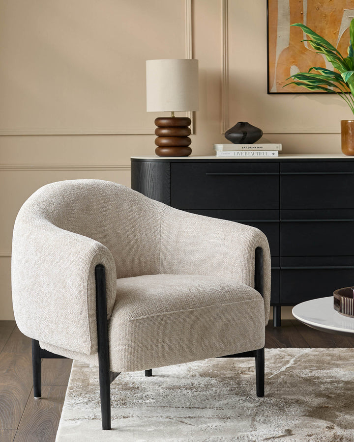 Stylish armchair with wooden legs, complemented by a sideboard, lamp and coffee table, creating a cosy living space.