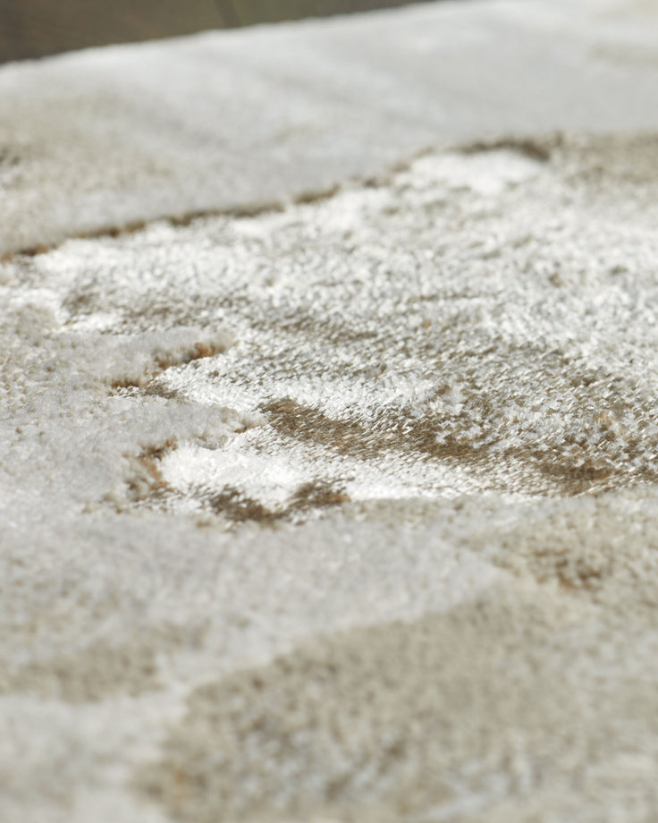 Close-up of a plush, textured rug in neutral tones. Great for adding warmth and comfort to any space.