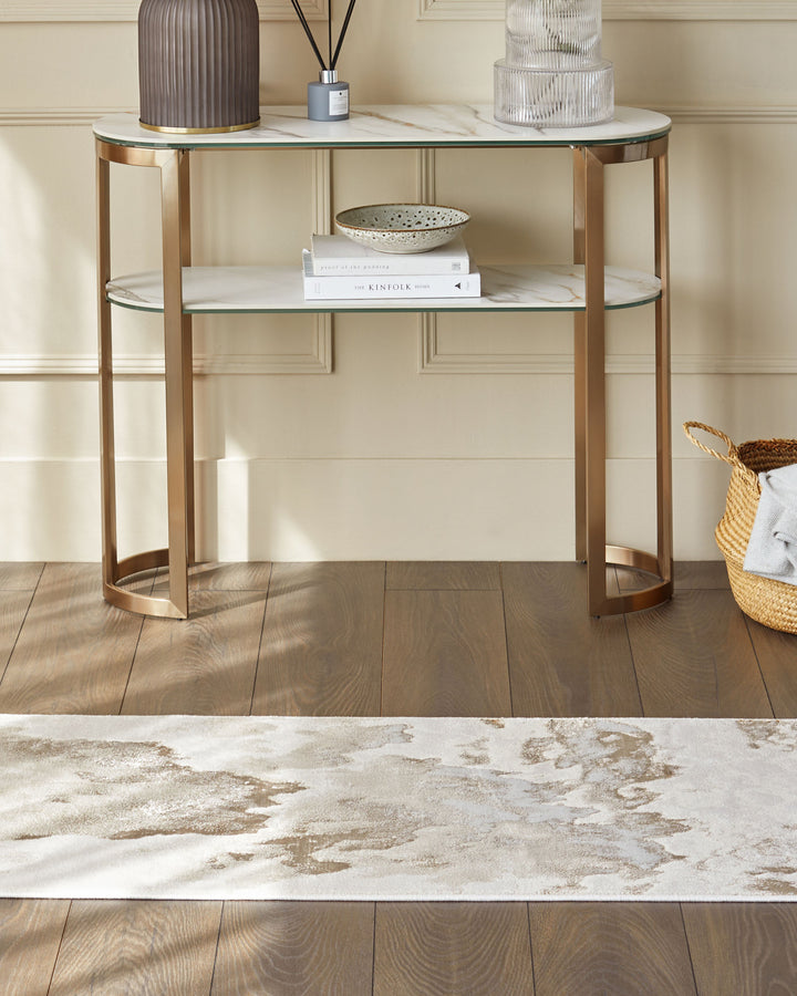 A two-tiered console table with a marble effect top, with decorative items. A basket sits to the right of the table.