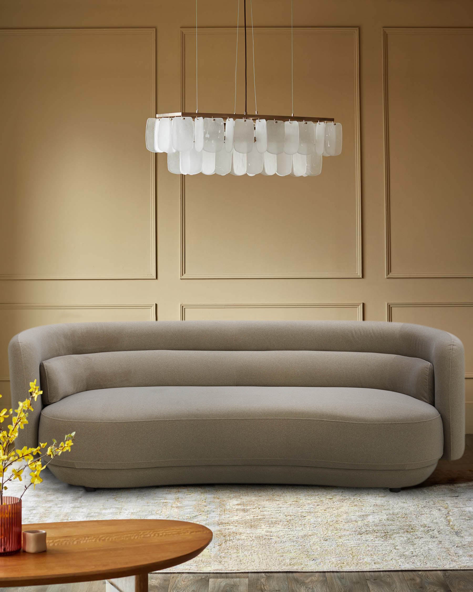 Stylish neutral-toned sofa under a unique chandelier, paired with a wooden coffee table and floral arrangement.
