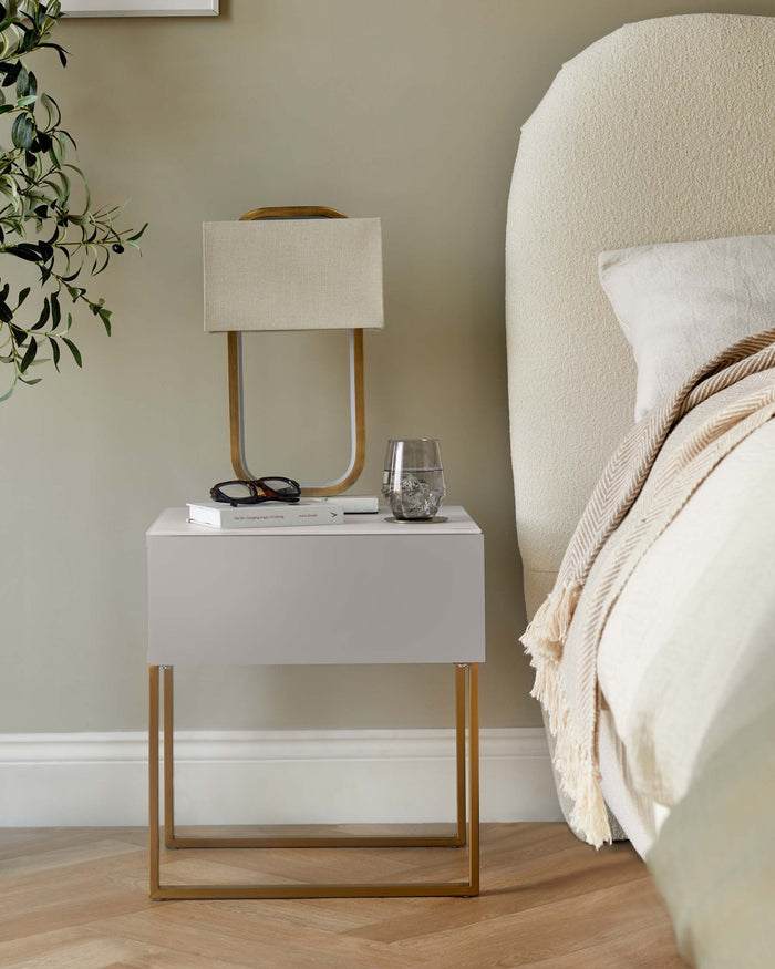 Bedside table with lamp, book and glass of water. Neutral tones. Bedroom furniture. Modern design.