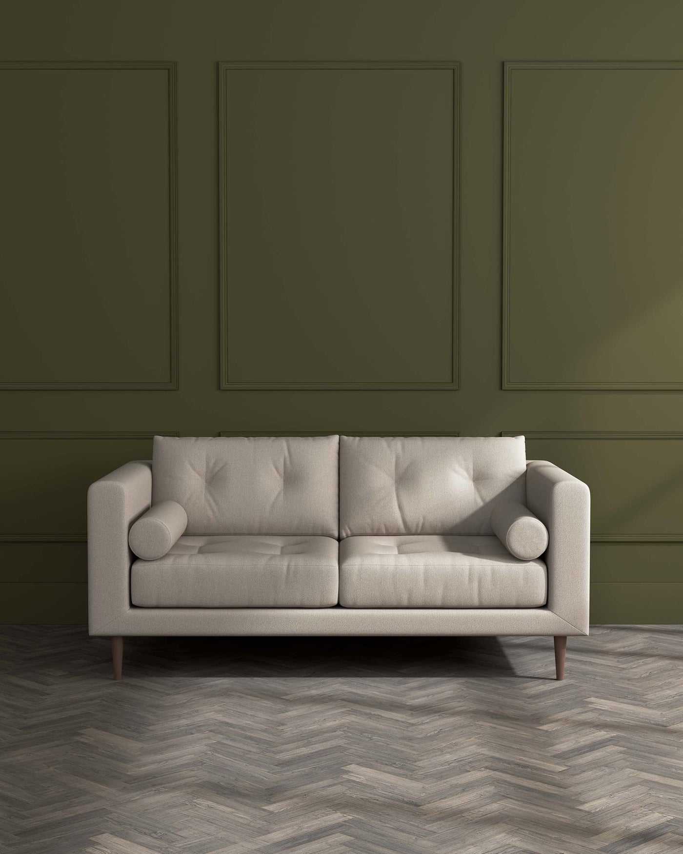 Modern three-seater sofa with a light beige upholstery and tufted backrest, featuring cylindrical side cushions and tapered wooden legs, set against a green panelled wall on a herringbone patterned wooden floor.