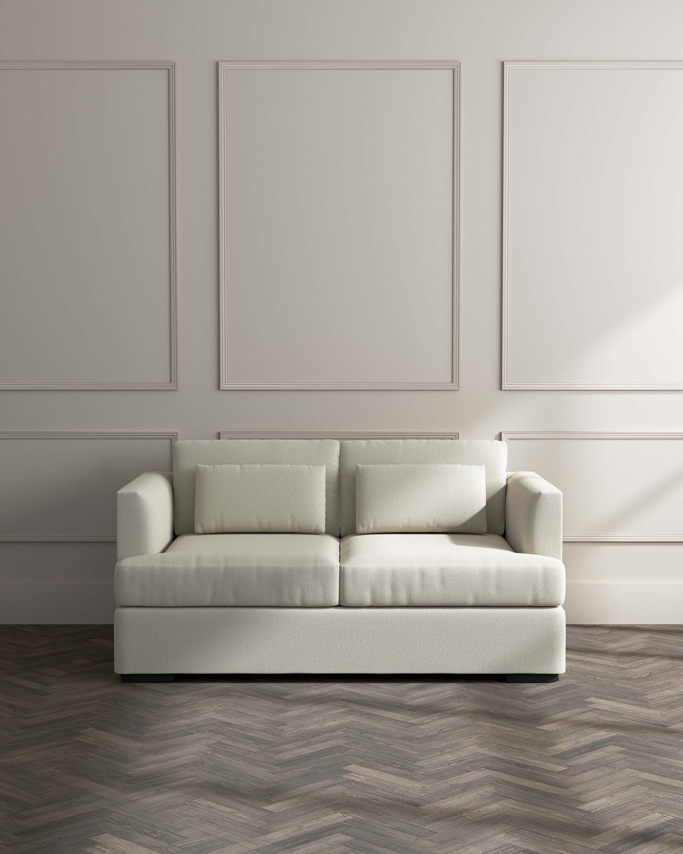 Modern minimalist off-white three-seater sofa with clean lines and plush cushions, set against a neutral wall with decorative mouldings and dark herringbone-patterned wood flooring.
