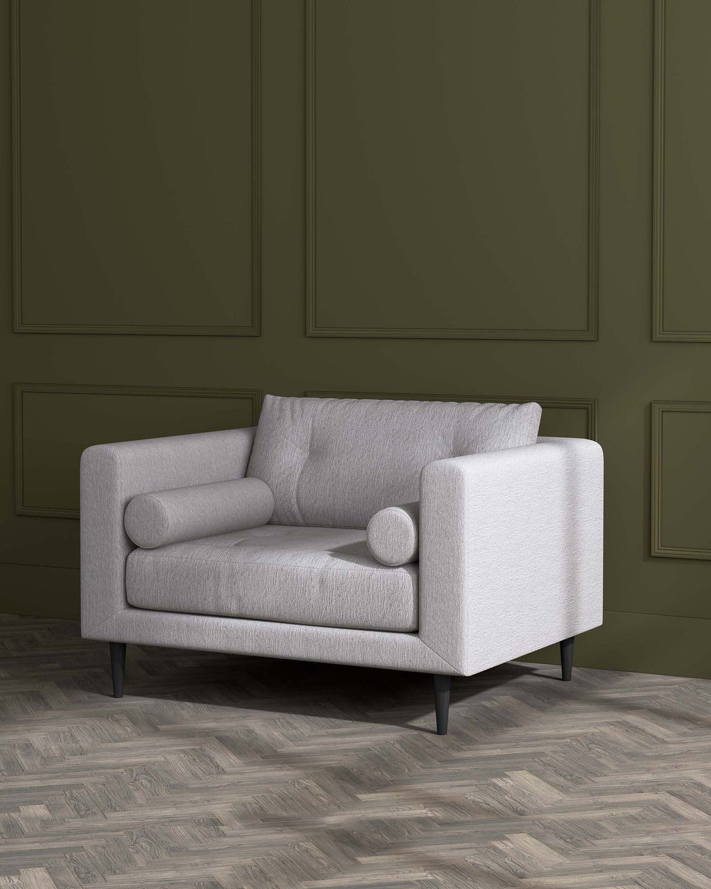 Modern minimalist light grey fabric loveseat with a clean-lined silhouette, featuring plush back and seat cushions, one cylindrical bolster pillow, flared armrests, and black tapered wooden legs. The sofa is showcased against a panelled olive green wall and a herringbone patterned wooden floor.