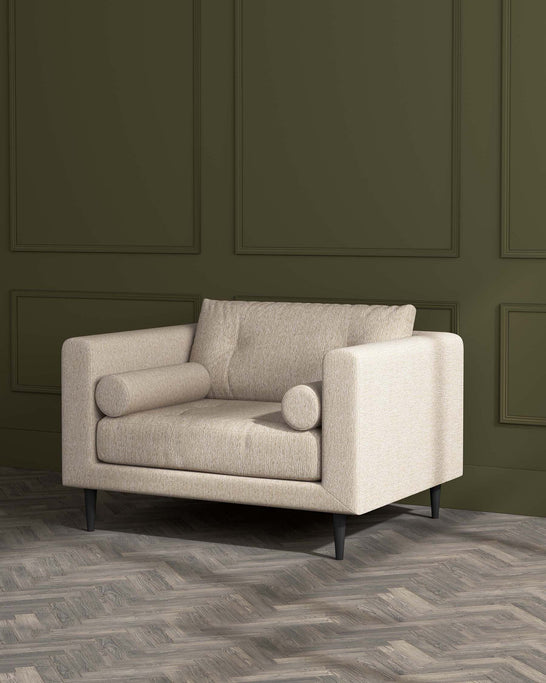 Modern beige two-seater sofa with clean lines and dark wooden legs set against a green panelled wall and herringbone parquet flooring.
