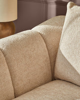 Genevieve 2-seater sofa in natural weave fabric, close-up of curved armrest and seat cushions with wooden leg detail.