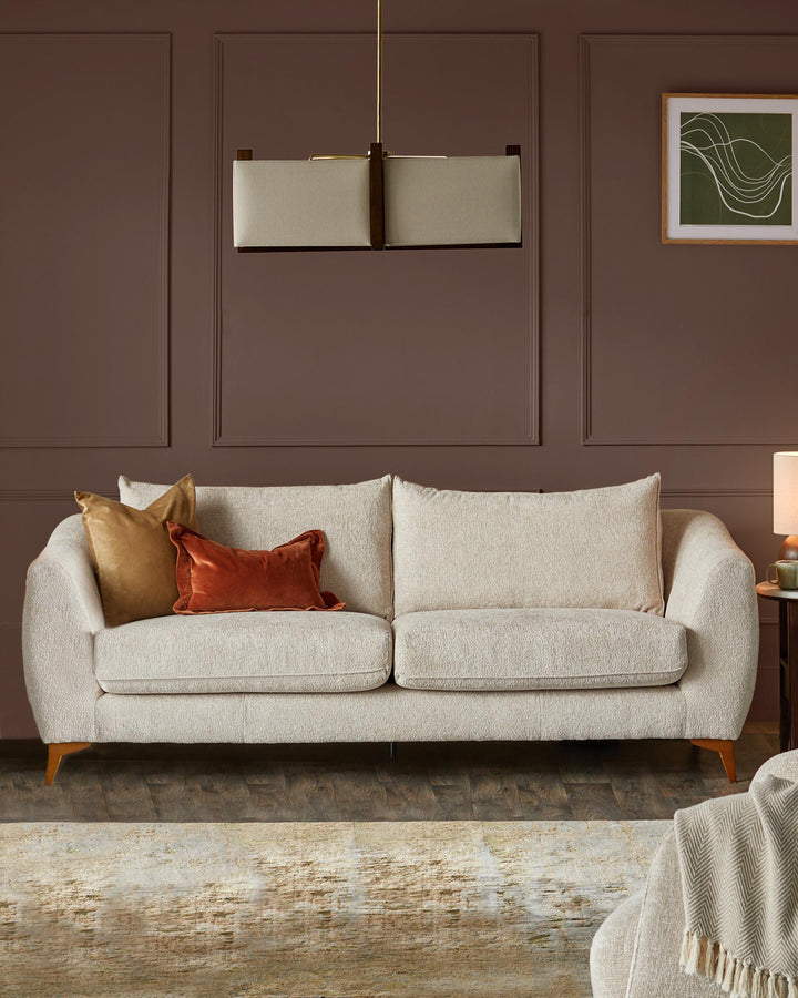 A comfy sofa with throw cushions in a modern living room setting with stylish lighting and decor.