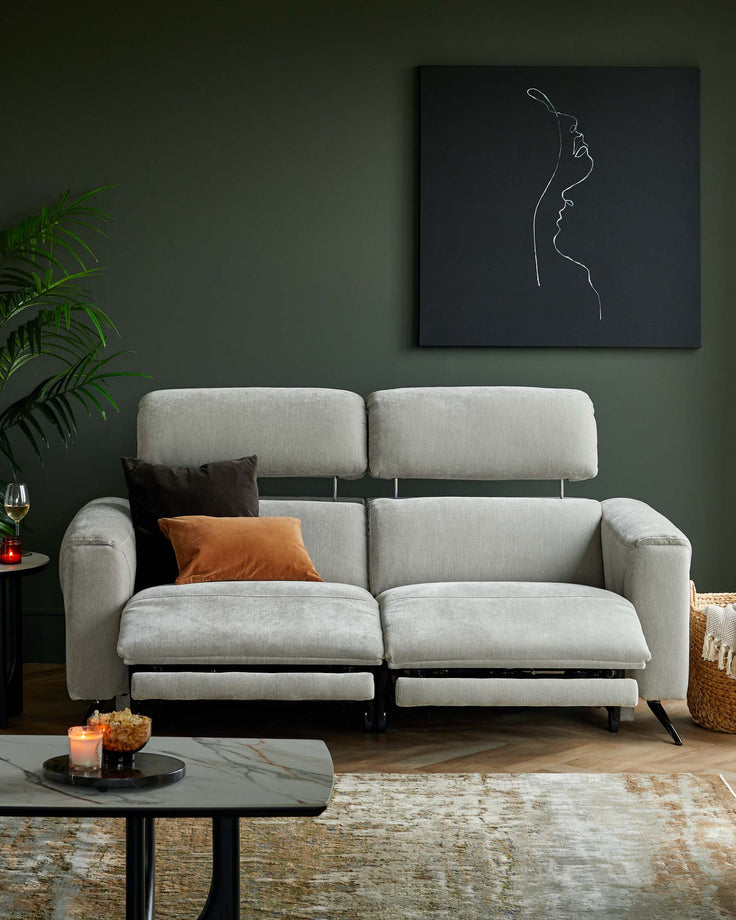 Stylish gray reclining sofa with plush cushions, accented by decorative pillows, paired with a modern marble coffee table.