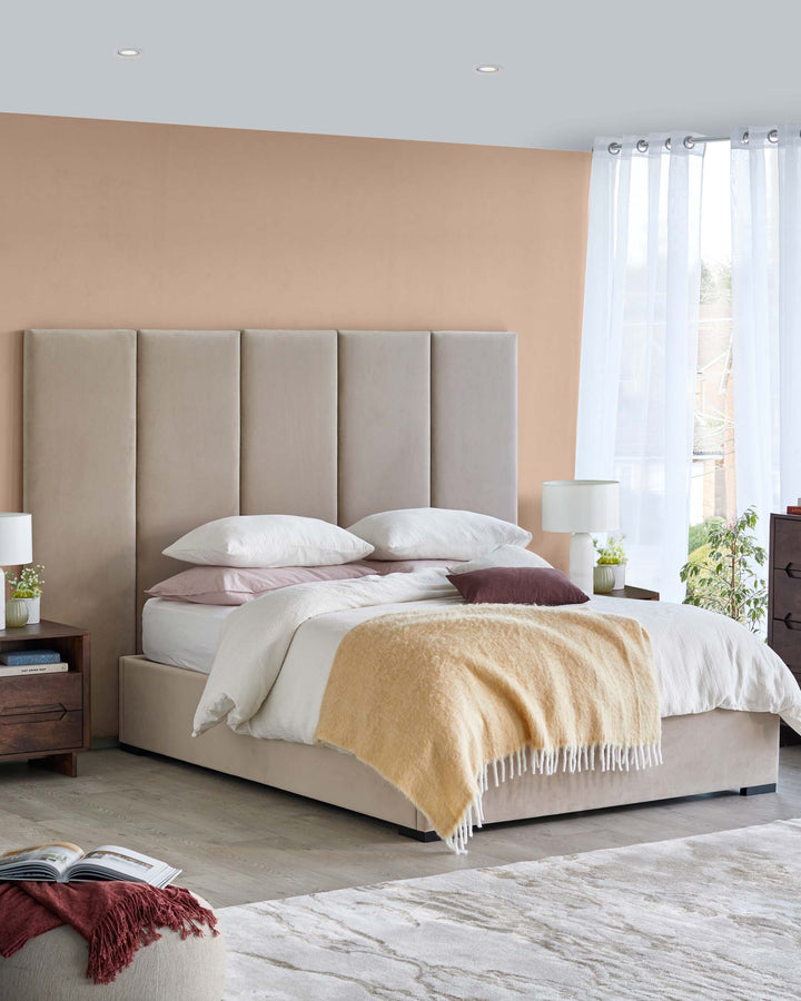 Modern bedroom featuring a sleek beige upholstered bed, cozy linens, wooden nightstands, a stylish lamp, and a textured rug.