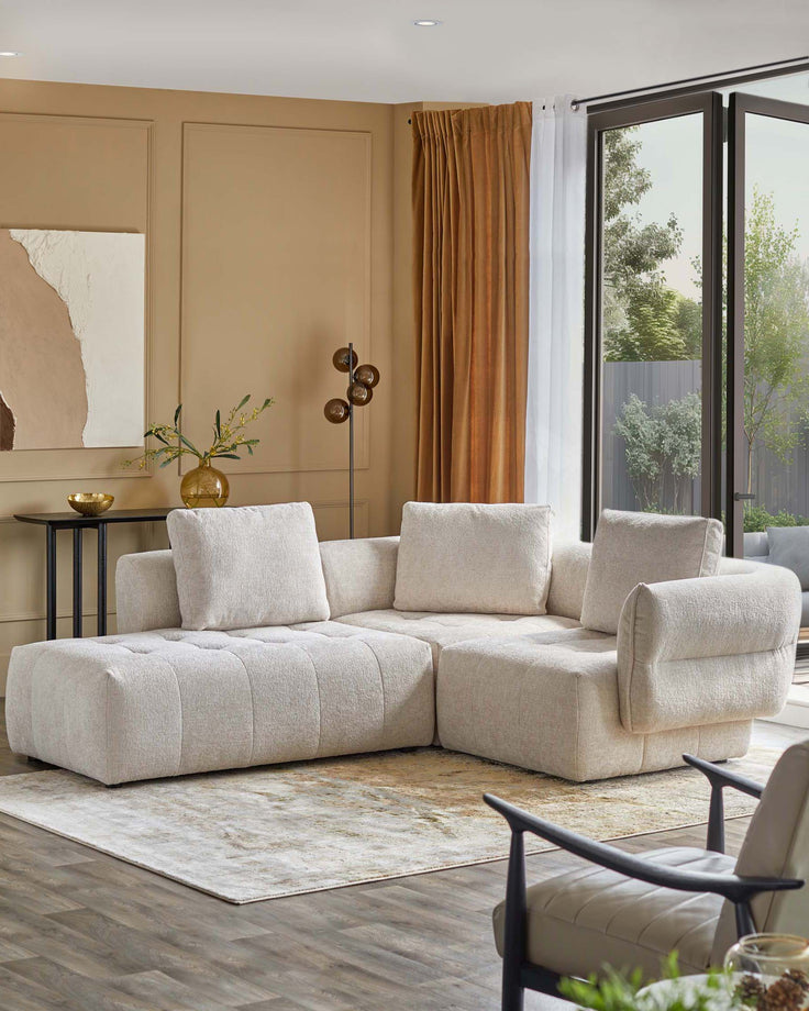 L-shaped plush sofa with textured fabric, accent pillows, a side table with a bowl, and elegant curtains in a stylish living space.