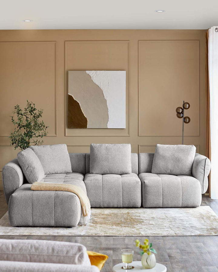 Lillian left corner chaise sofa in light grey weave fabric, displayed in a modern living room setting with neutral décor.