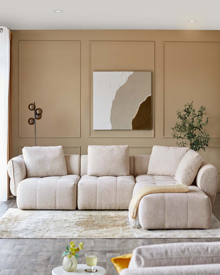 Cozy beige sectional sofa with plush cushions, accentuated by a soft throw, paired with a stylish rug and modern decor elements.