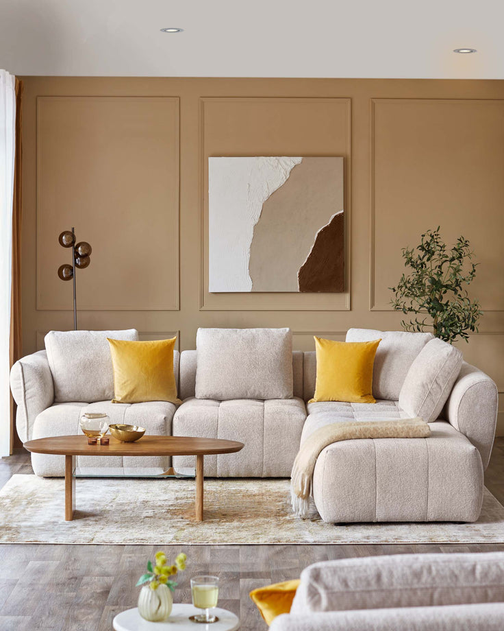 Luxe cream sectional sofa with yellow accent pillows, paired with a sleek wooden coffee table on a soft area rug.