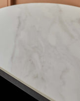 Close-up of a round marble table top with a dark wood frame. Stylish and modern furniture detail.