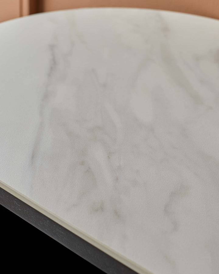 Close-up of a round marble table top with a dark wood frame. Stylish and modern furniture detail.