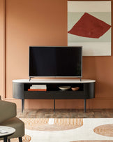 Contemporary media unit with marble top and dark wood frame, housing a TV and decorative items, complemented by a patterned rug.