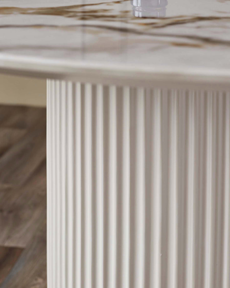 Austin 6-seater dining table with white fluted pedestal base and natural ceramic top, close-up detail view.