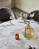 Austin 6-seater dining table in natural marble finish with gold veining, styled with chairs and table setting.
