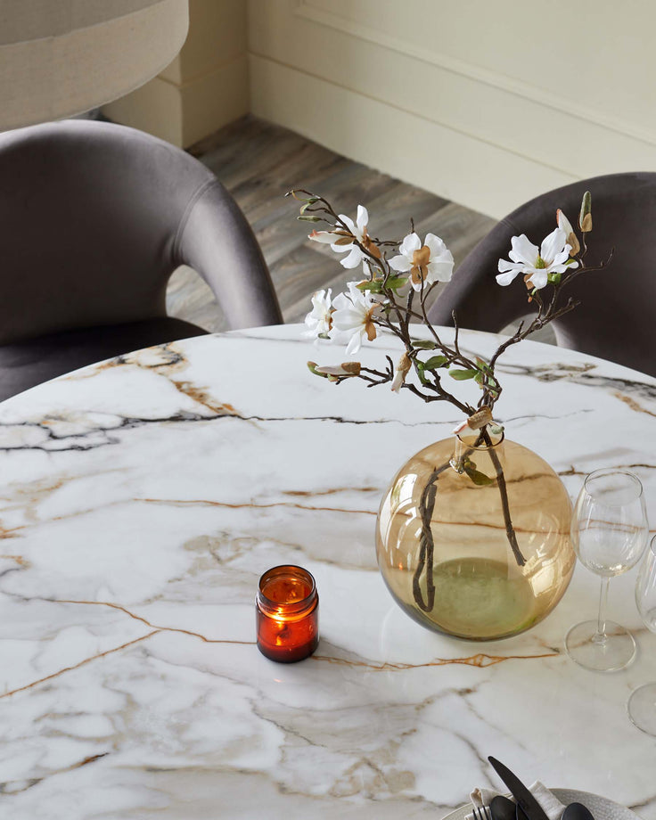 Austin 6-seater dining table in natural marble finish with gold veining, styled with chairs and table setting.