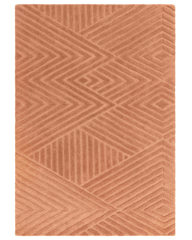Textured coral rug with geometric patterned lines, showcasing a modern, plush floor covering for interior spaces.