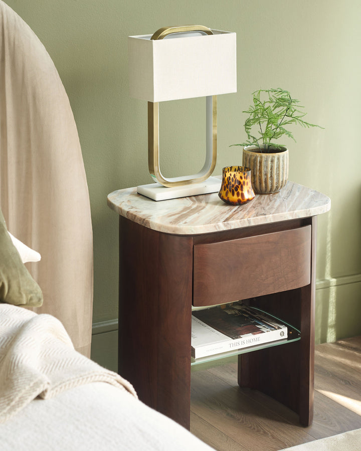 Adalynn bedside table in dark wood with marble top, featuring a drawer, open shelf, and brass handle detail.