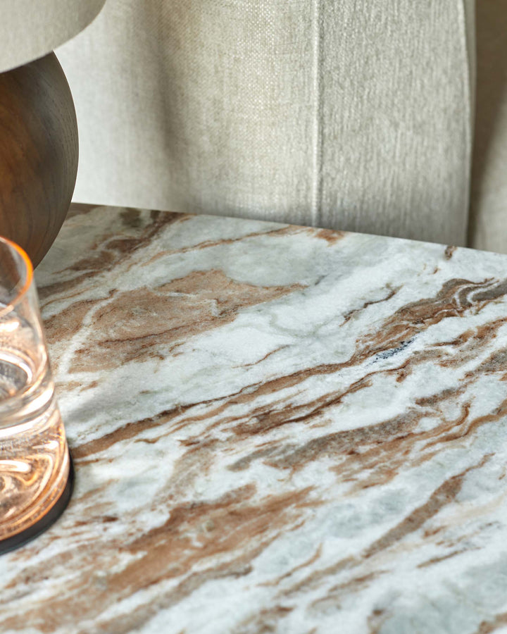 Marble tabletop featuring lamp and glass, evoking a blend of natural elegance and modern design, ideal for stylish interiors.