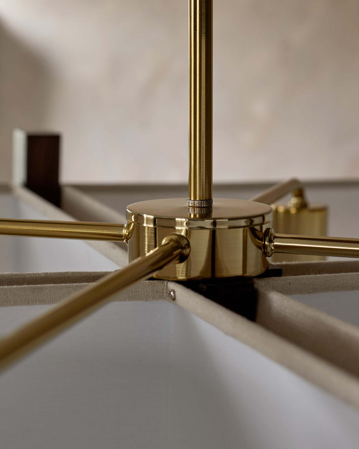 Close-up of a gold chandelier with fabric shade, showcasing its elegant design and fixture details.