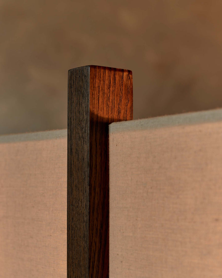 Close-up of a timber-framed furniture piece with fabric panel. Minimalist and modern design.