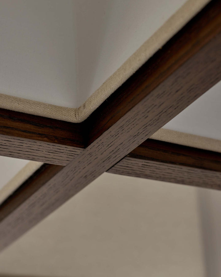 A close-up showing the detailed wooden framework and fabric covering of a stylish piece of furniture.