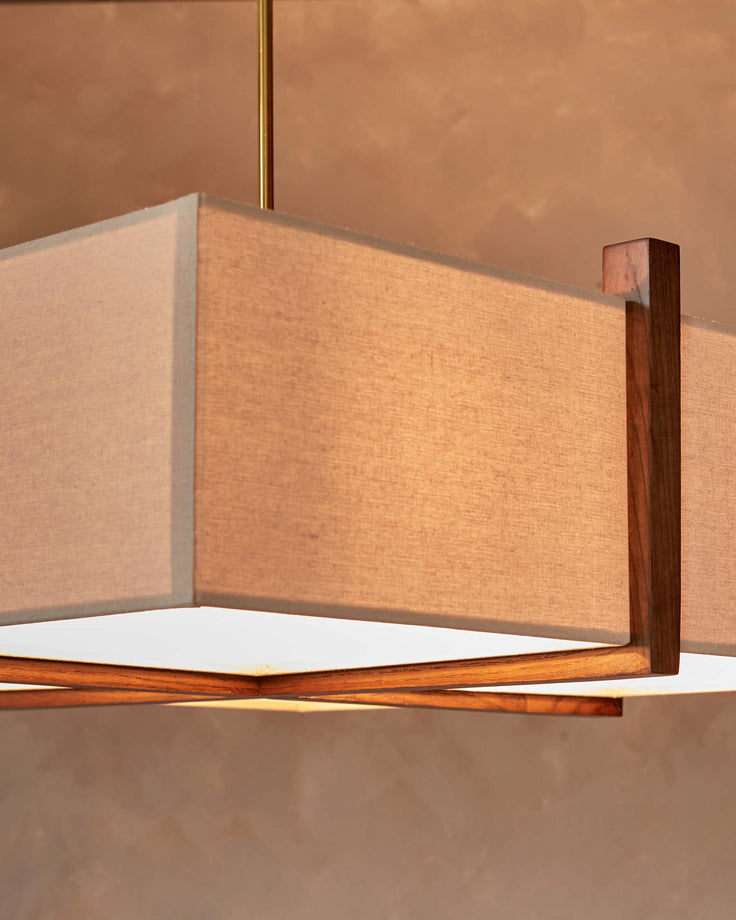 A modern boxy light fixture with a neutral fabric shade and wooden frame hangs from the ceiling.