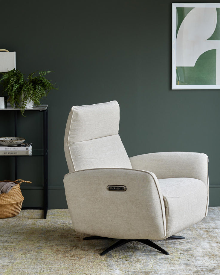 A stylish, oat coloured recliner chair. Dark green wall. Shelves with plant, books and artwork complete the scene.