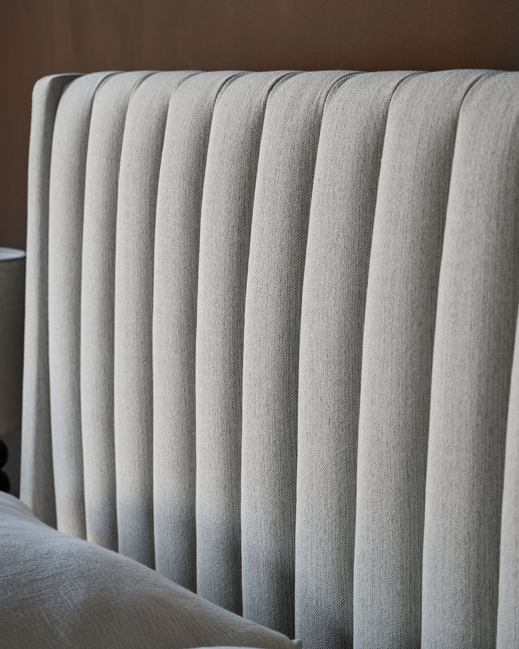 Amalfi fabric double bed with storage in ivory, showing close-up of vertical channel quilting on headboard.