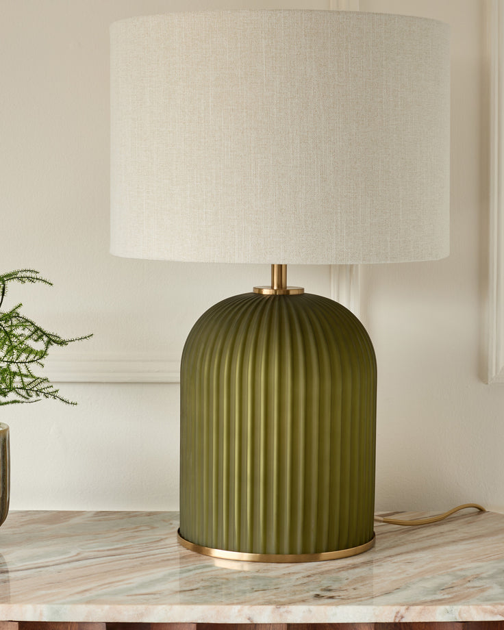 Amalfi table lamp with olive green ribbed ceramic base, brass accents, and cream linen shade on marble surface.
