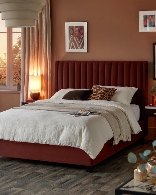 A stylish bedroom featuring a plush red bed with a vertically channelled headboard and neutral coloured bedding.