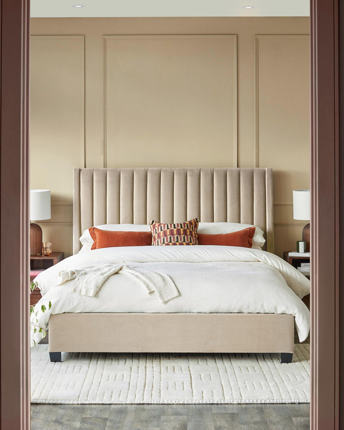 A luxurious bedroom with a velvet headboard, plush rug, and stylish bedside tables. Perfect for a restful night's sleep.