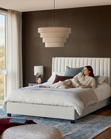 Amalfi Fabric Double Bed in ivory with vertical channel stitching headboard, displayed in a styled bedroom setting.