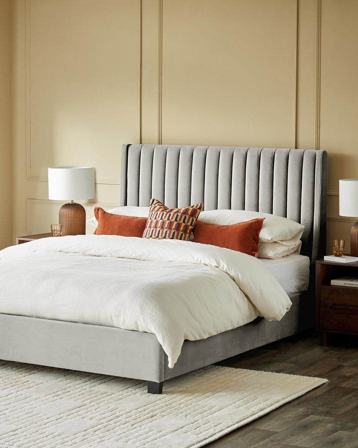 A luxurious double bed featuring a light grey, vertically-stitched headboard and rustic wooden side tables with lamps.