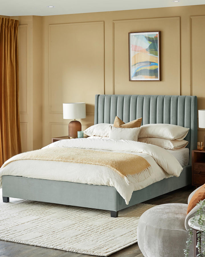 A plush bedroom scene with upholstered bed, bedside tables, lamps and a cosy rug.