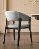 Amelia dining chair in light grey leather with black wooden frame, shown in room setting with beige walls.