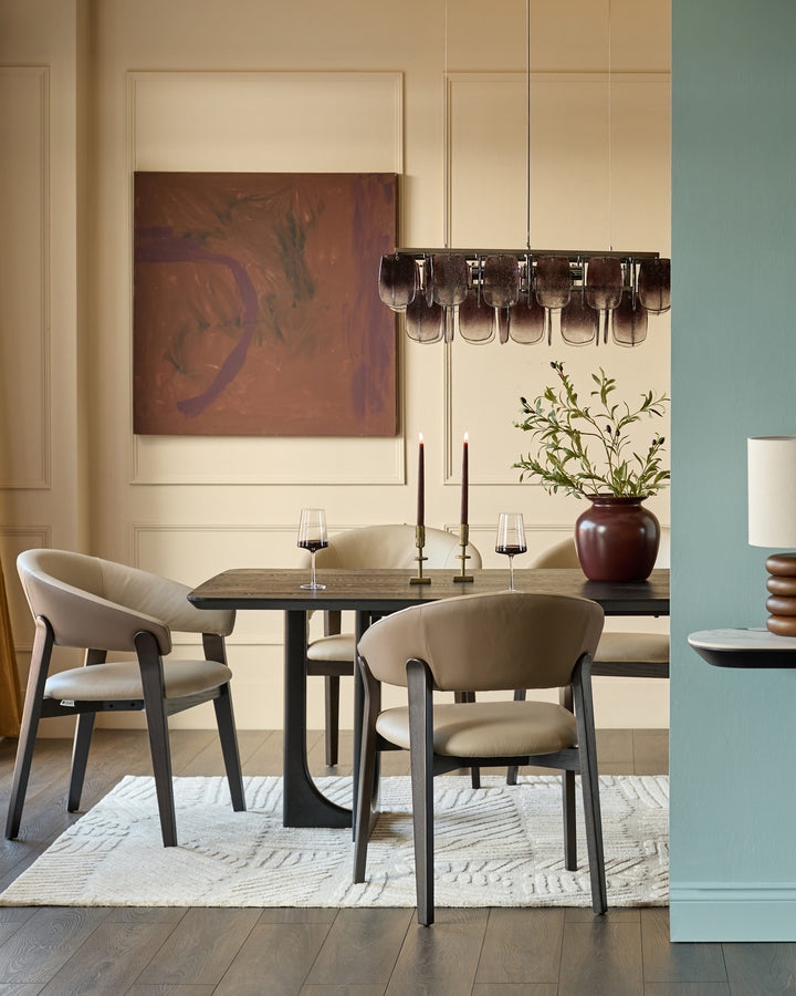 Amelia dining chair in natural leather with mocha wood frame, shown in modern dining setting at table.
