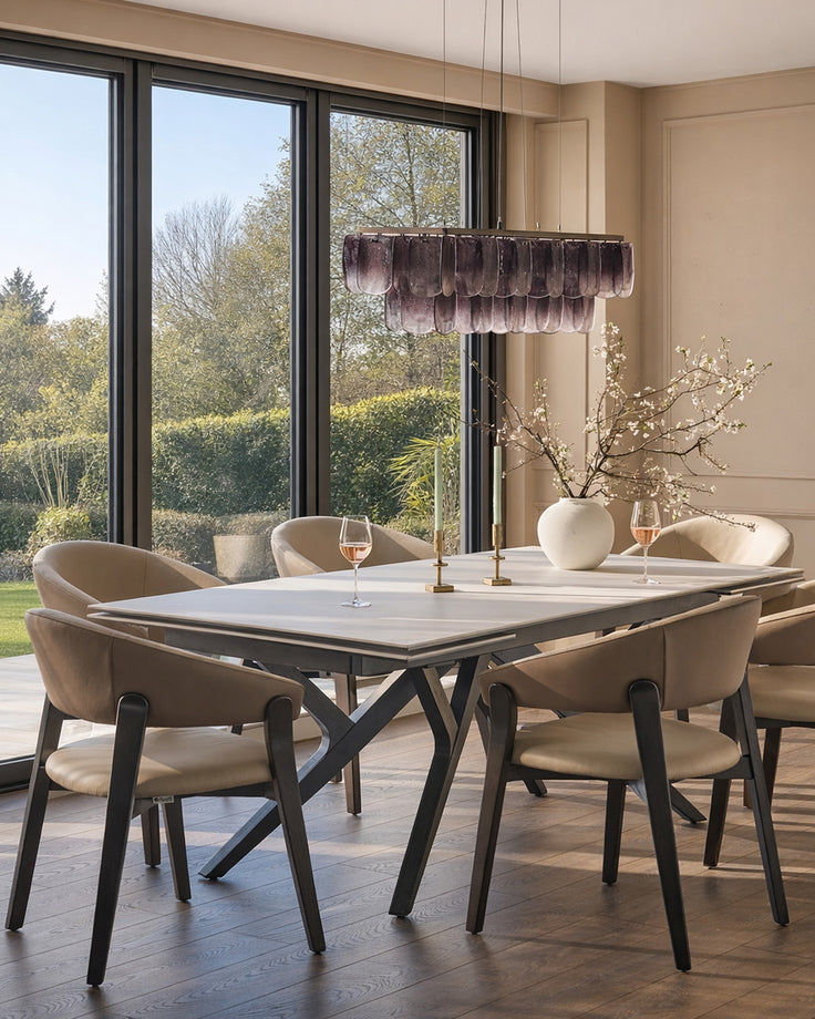Amelia dining chair in natural leather and mocha finish, shown at modern dining table in bright dining room with garden views.