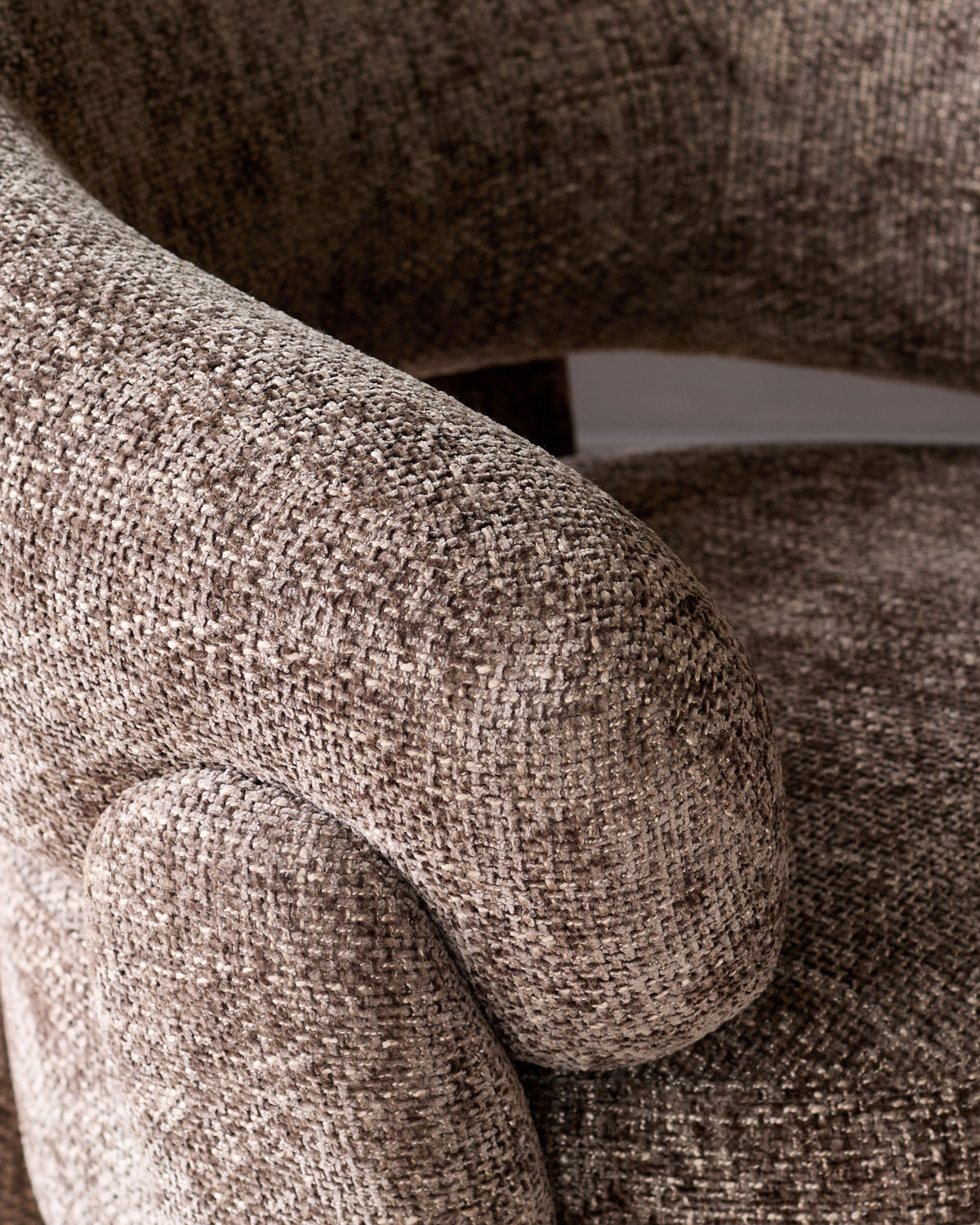 Anya accent chair in mocha fabric, close-up detail of textured weave and curved armrest.