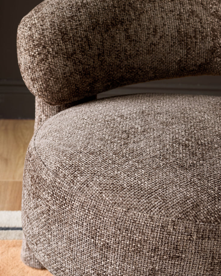 Anya accent chair in mocha fabric, close-up detail showing curved rolled armrest and seat upholstery texture.