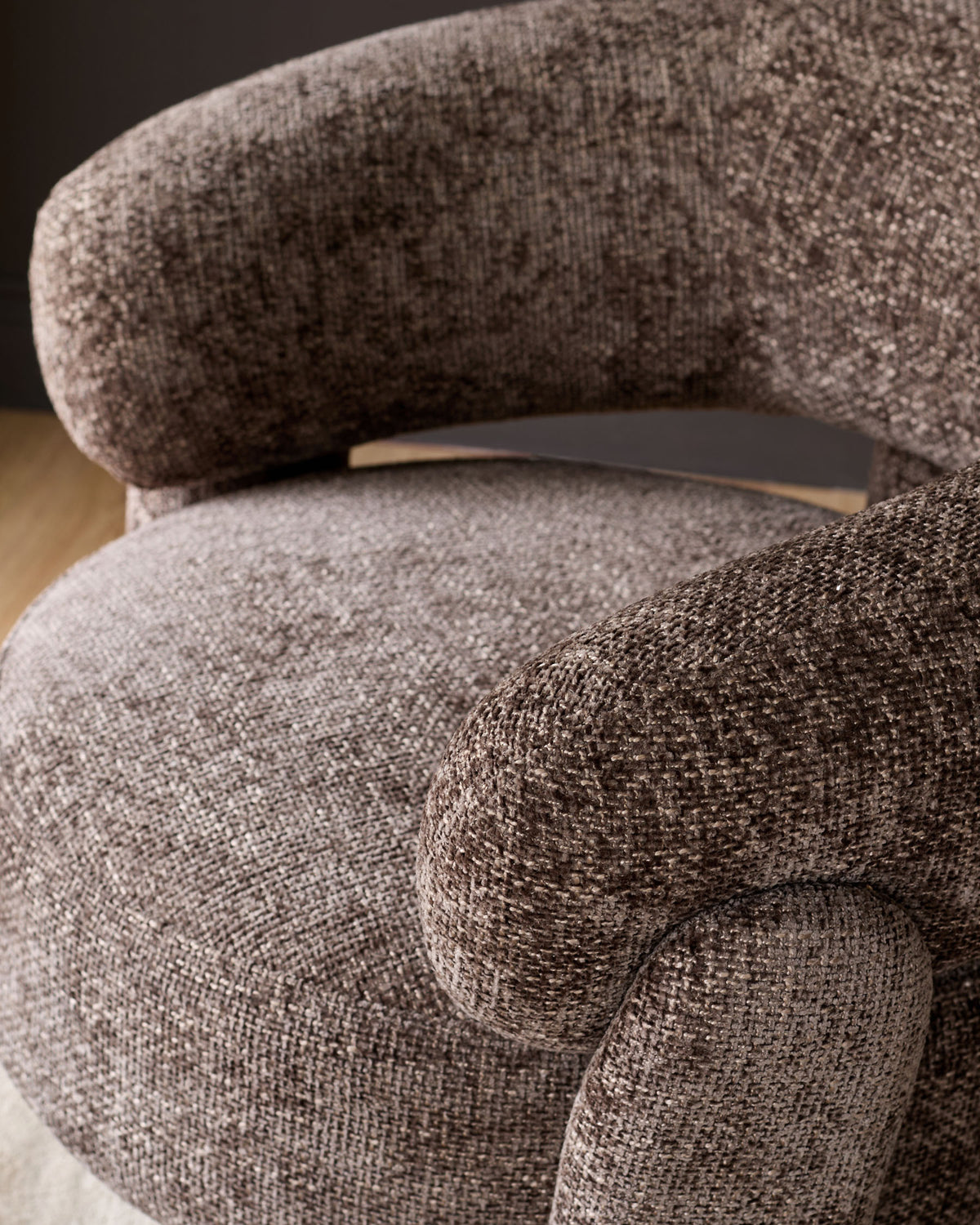 Anya accent chair in mocha fabric, close-up detail showing curved armrest and plush upholstery texture.