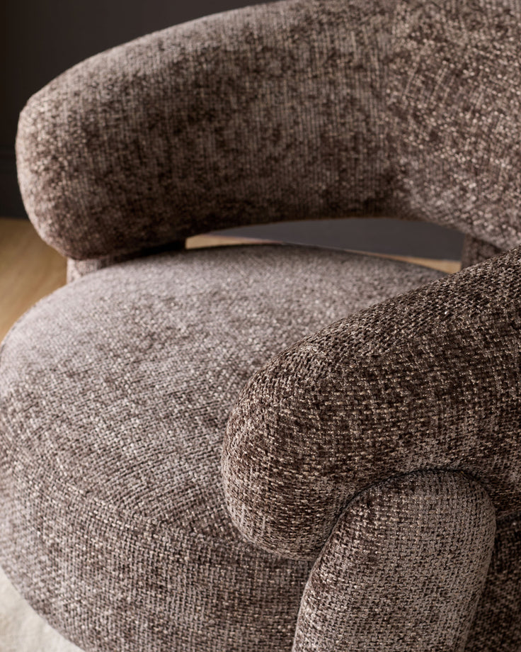 Anya accent chair in mocha fabric, close-up detail showing curved armrest and plush upholstery texture.