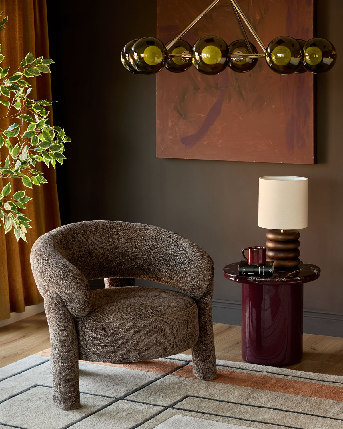 Mocha fabric accent chair with curved barrel shape and cylindrical legs, displayed in a styled living room setting.