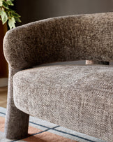 Anya accent sofa in mocha fabric, showing curved armrest and seat detail from side angle.