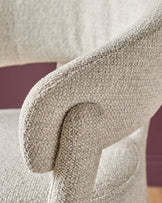 Anya bar stool in natural fabric, close-up of curved armrest detail and woven textile texture.