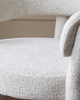 A close up shot of a stylish, textured light grey chair. Ideal for adding a modern touch to any living space.