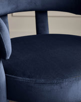Close-up of a stylish blue velvet chair, showcasing the soft texture and elegant design. Perfect for a touch of luxury.